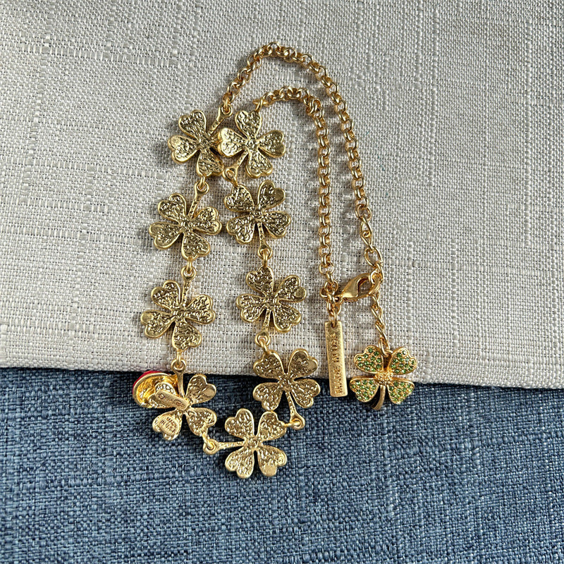 Four-leaf clover necklace with green textured flowers, red ladybug charm, gold links
