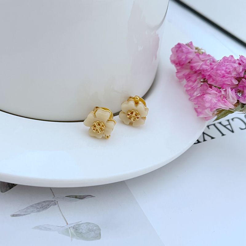 Four-leaf clover stud earrings with white acrylic and gold-tone settings
