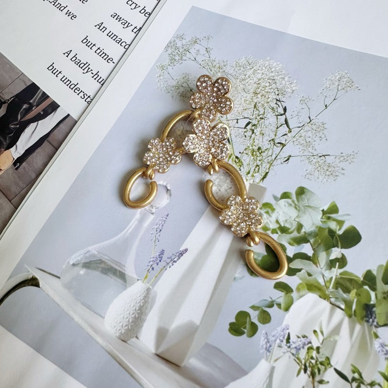 Gold floral drop earrings with clear crystal clover and dangling oval links