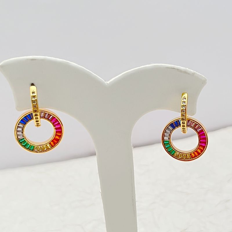 Rainbow zircon donut hoop earrings, gold-tone setting shown on white display stand