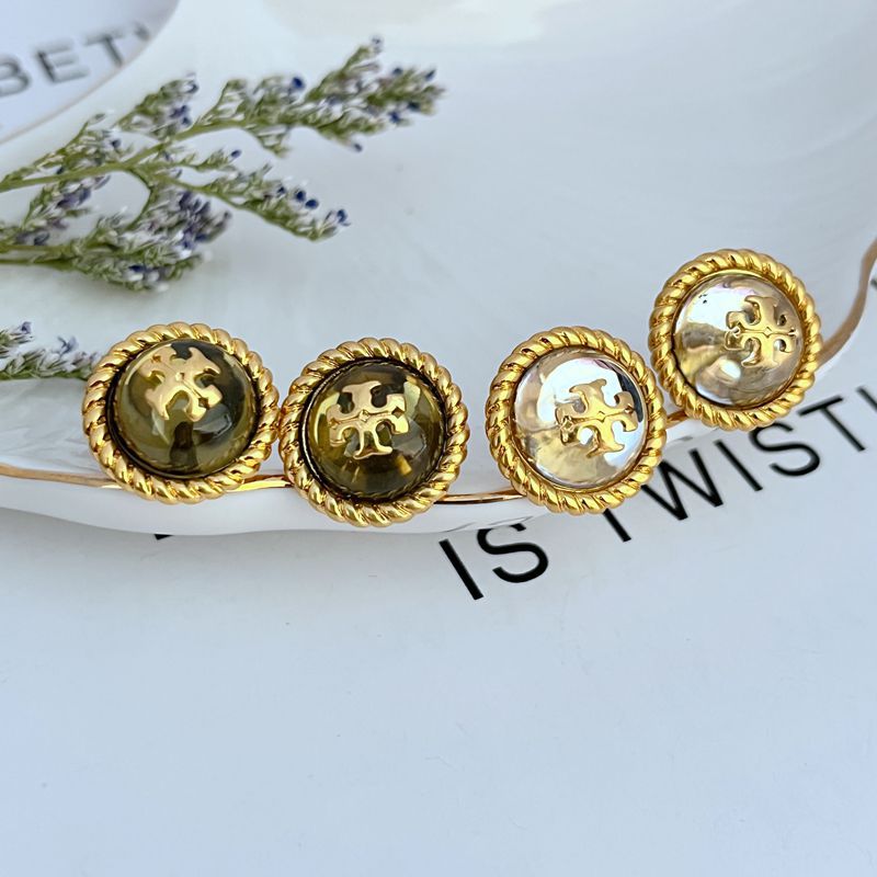 Gold-tone round stud earrings with scalloped edge and logo medallion detail