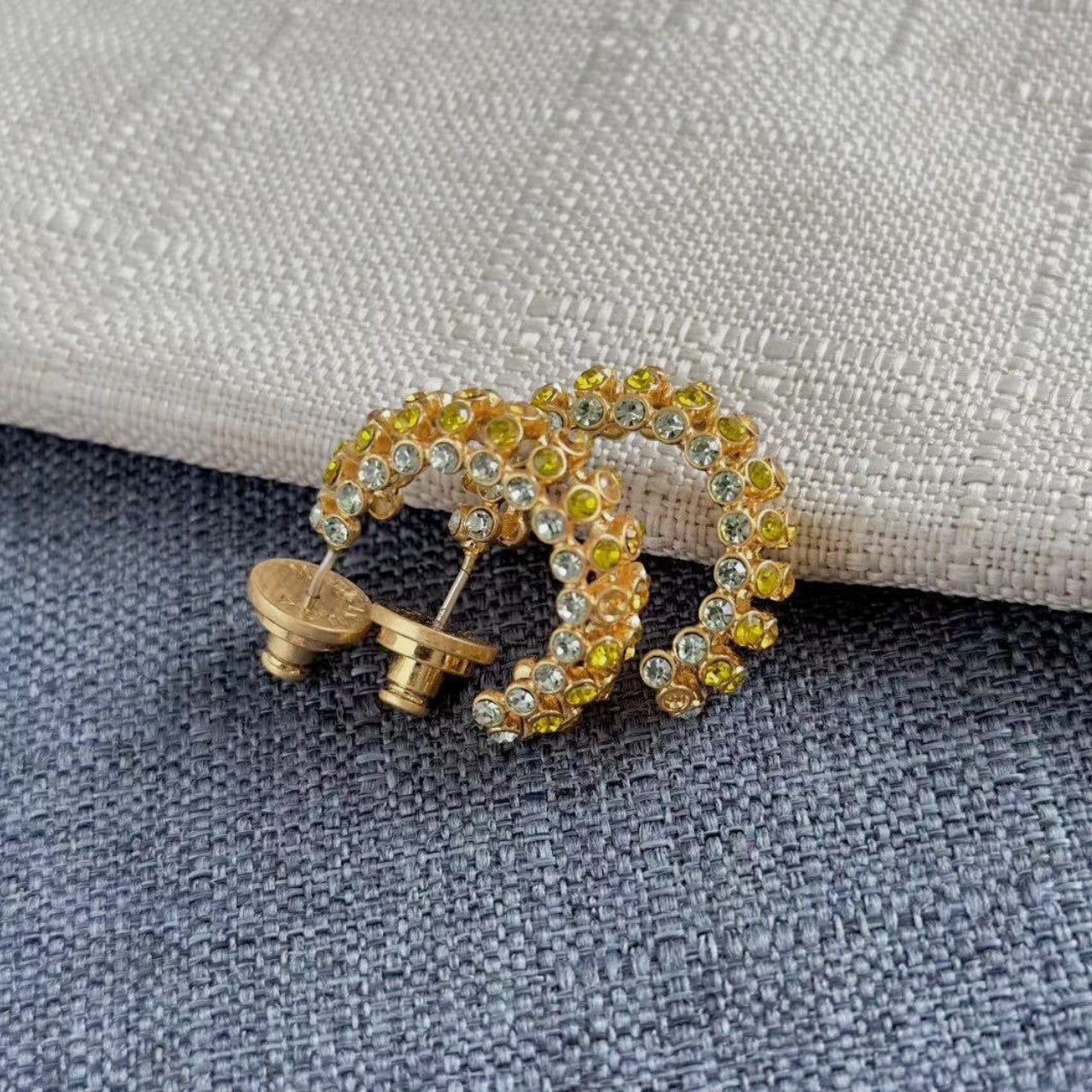 Gold-tone cubic zirconia C-hoop earrings with yellow and clear stones; stud backs