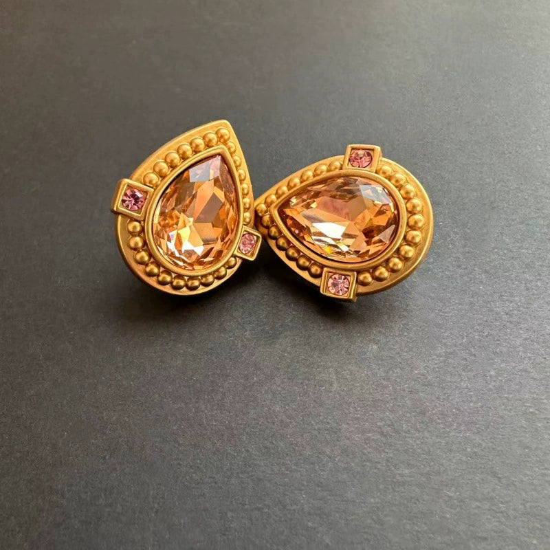 Gold-tone heart-shaped crystal clip-on stud earrings with amber center stones and pink accents