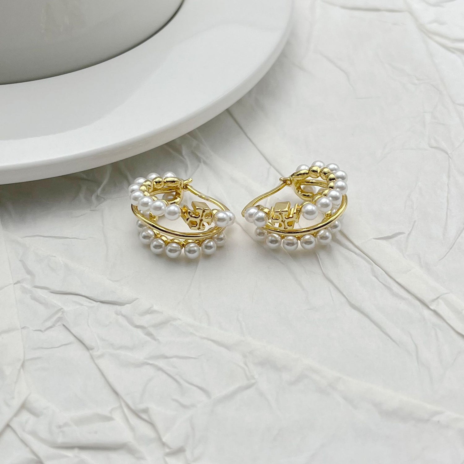 Gold multi-hoop earrings with faux pearl rows and open hoop design.