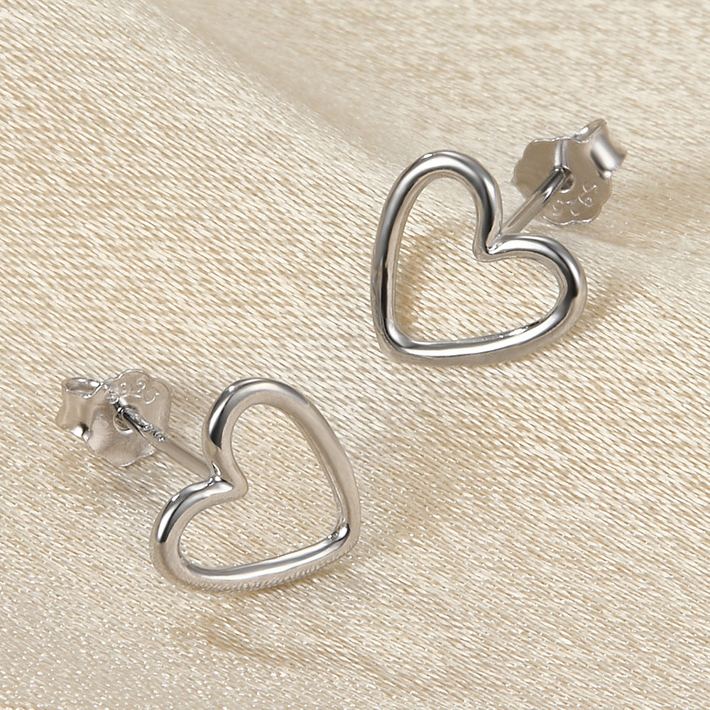 Heart-shaped stud earrings, silver tone, hollow heart outline, butterfly backs