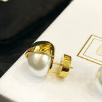 White pearl stud earrings with gold-tone outer shell and post back