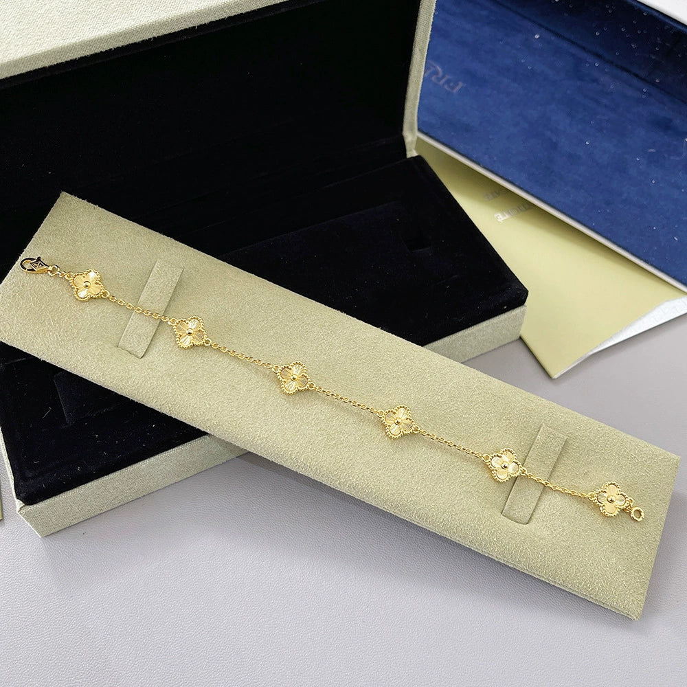 Gold-tone four-leaf clover bracelet with small engraved clover links and clasp
