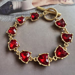Red crystal heart link bracelet with gold-tone clasp and oval connector links
