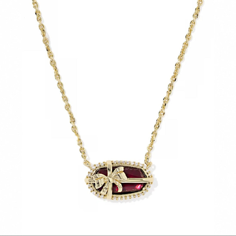 Elisa bow pendant necklace with deep red center stone, gold chain and pavé edge