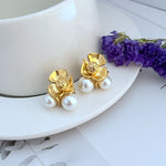 Goldfarbene Blumen-Ohrringe mit zwei weißen Perlen, Metall-Studs