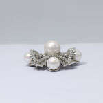 White-gold tone pearl and crystal brooch, round pearl center with four curved pearls