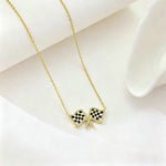 Gold chain necklace with checkered flag bow pendant at center