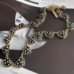 Green rhinestone heart necklace with gold-tone chain and heart charm accents