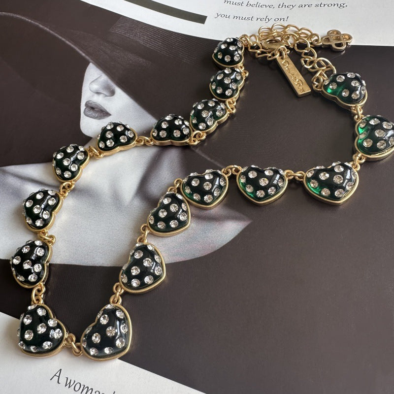 Green rhinestone heart necklace with gold-tone chain and heart charm accents