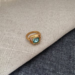 Vintage-style square ring with light blue/teal stone and gold textured setting