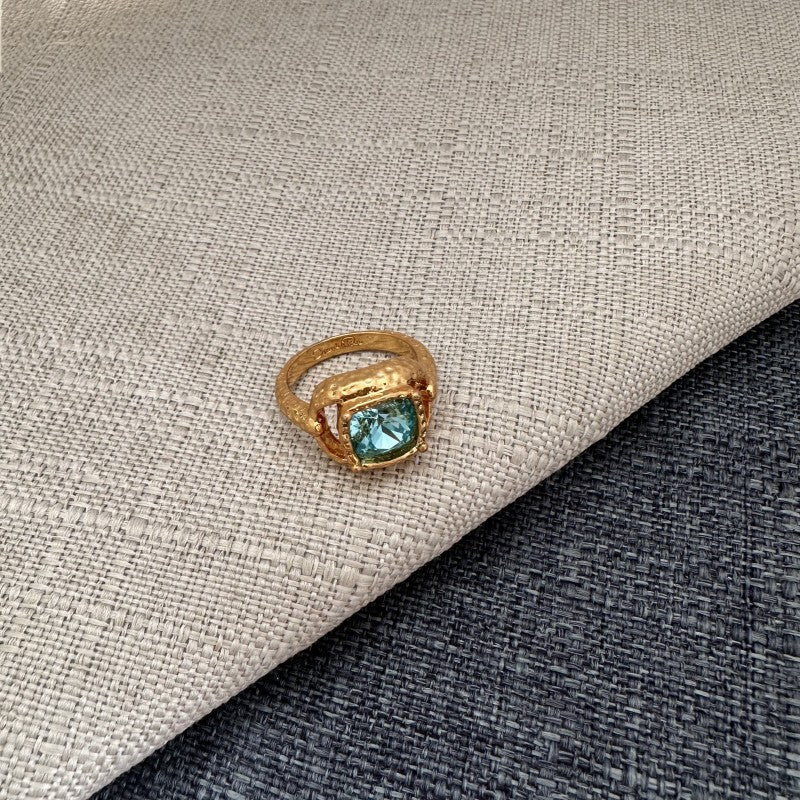Vintage-style square ring with light blue/teal stone and gold textured setting