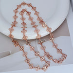 Rose gold four-leaf clover sweater chain with linked clover charms and clasp