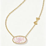Gold-tone oval pendant necklace with pink floral cabochon and bow accent