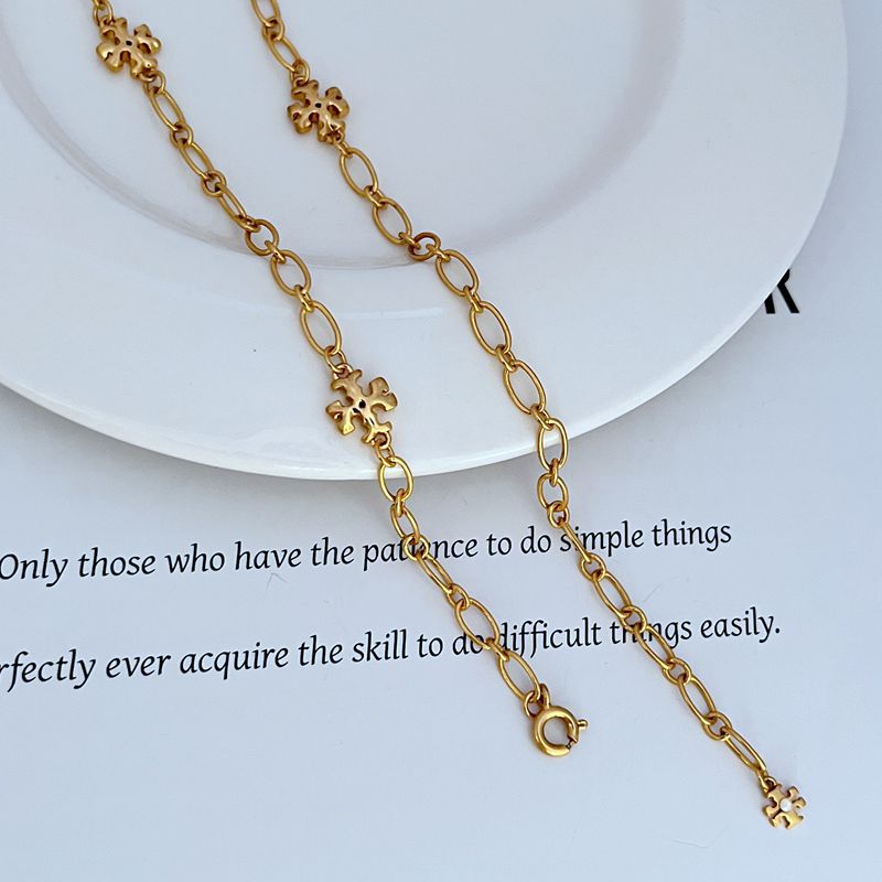 Interlocking logo charm necklace, gold-tone oval links with clover centerpiece charms
