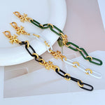 Chunky chain logo bracelets with gold-tone charms on black and green links
