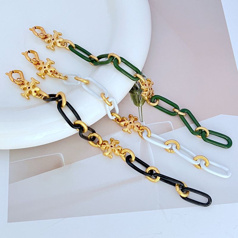 Chunky chain logo bracelets with gold-tone charms on black and green links