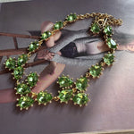 Gold-tone link crystal necklace with green teardrop and oval faceted stones