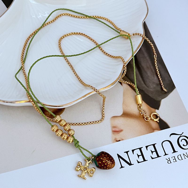 Gold beaded double necklace with raspberry enamel pendant and green cord accents