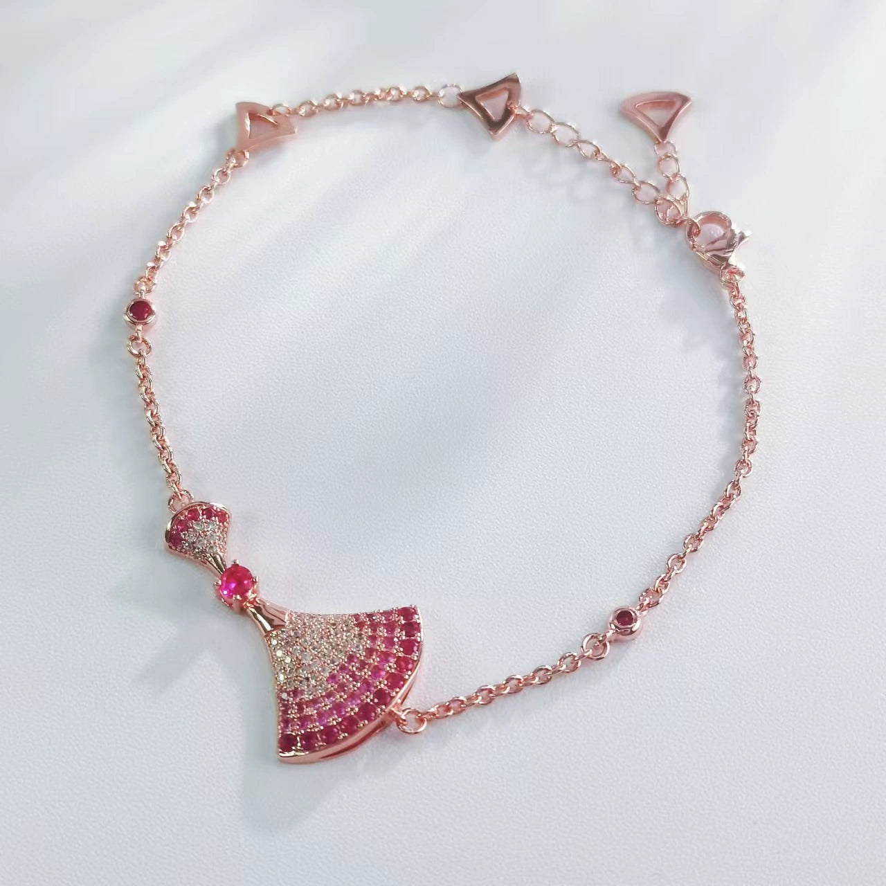 Rose gold rhinestone bow charm bracelet with fan-shaped bow and pink crystals