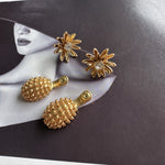Gold diamond flower earrings with clear centers and gold textured pineapple dangle backs