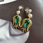 Gold-tone tulip earrings with dark green pear crystal, green accents, and pearl dangles