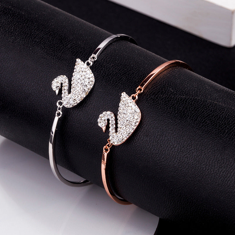 Swan charm bracelets in silver and rose gold with pavé stones on a cuff