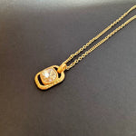 Gold-tone hammered square pendant necklace with faceted clear gemstone