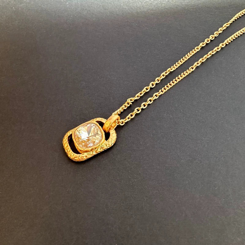 Gold-tone hammered square pendant necklace with faceted clear gemstone