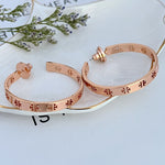 Roségoldfarbene große Creolen mit geometrischem Cutout-Logo und Stiftverschluss