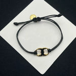 Pulsera ajustable con cordón negro y dije esmaltado blanco con aro dorado