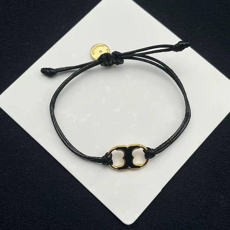 Pulsera ajustable con cordón negro y dije esmaltado blanco con aro dorado