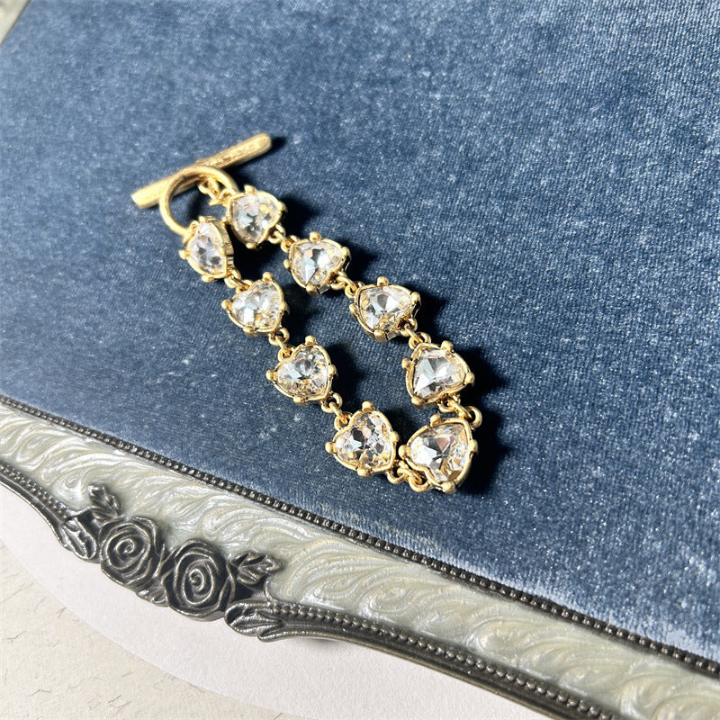 Clear crystal heart link bracelet with gold-tone chain and bar-and-ring clasp