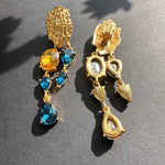 Gold clip-on style earrings with orange and blue teardrop crystal drops