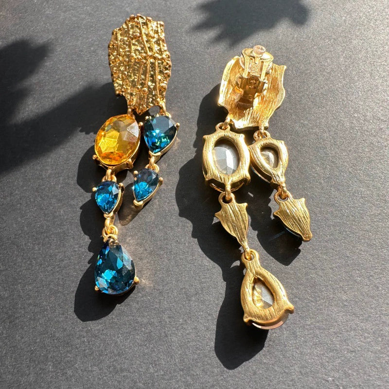 Gold clip-on style earrings with orange and blue teardrop crystal drops