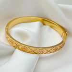 Gold logo-pattern hinged bangle bracelet, side view with etched linework