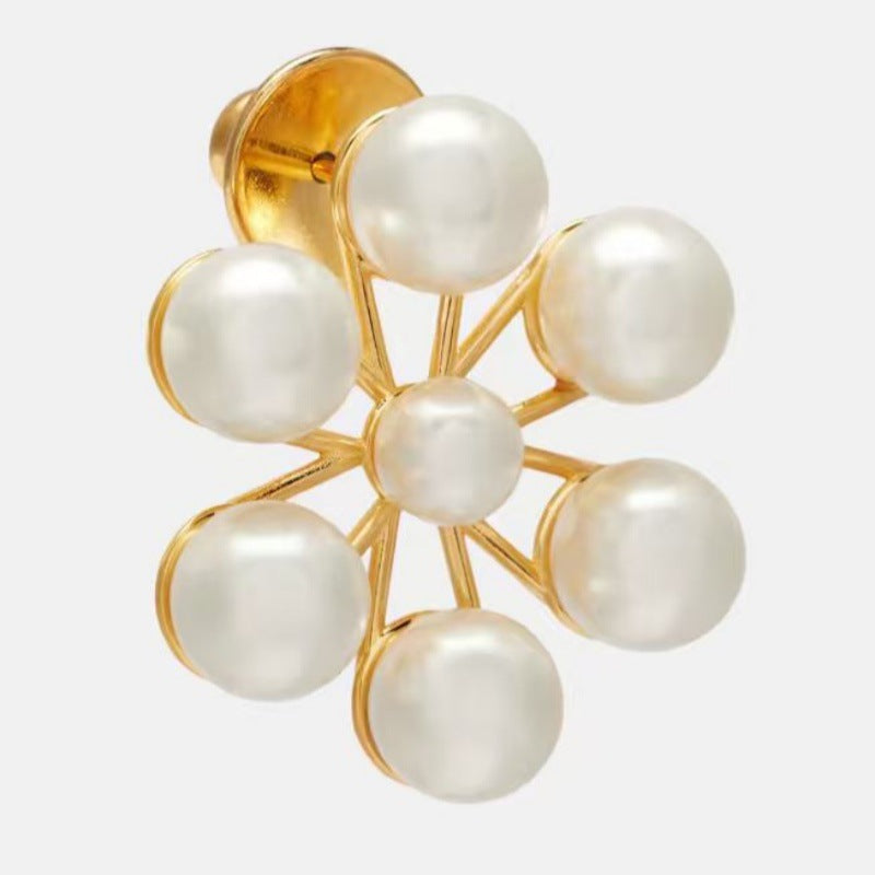 Close-up of gold-tone Ferris wheel pearl floral earring with ear post