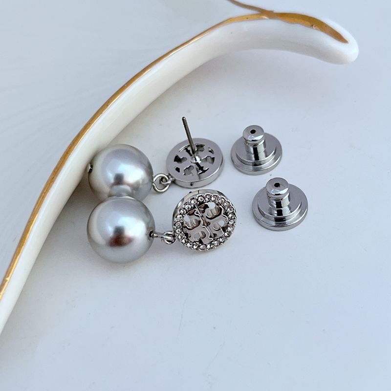 Pearl drop earrings with round logo disc and butterfly back clasps