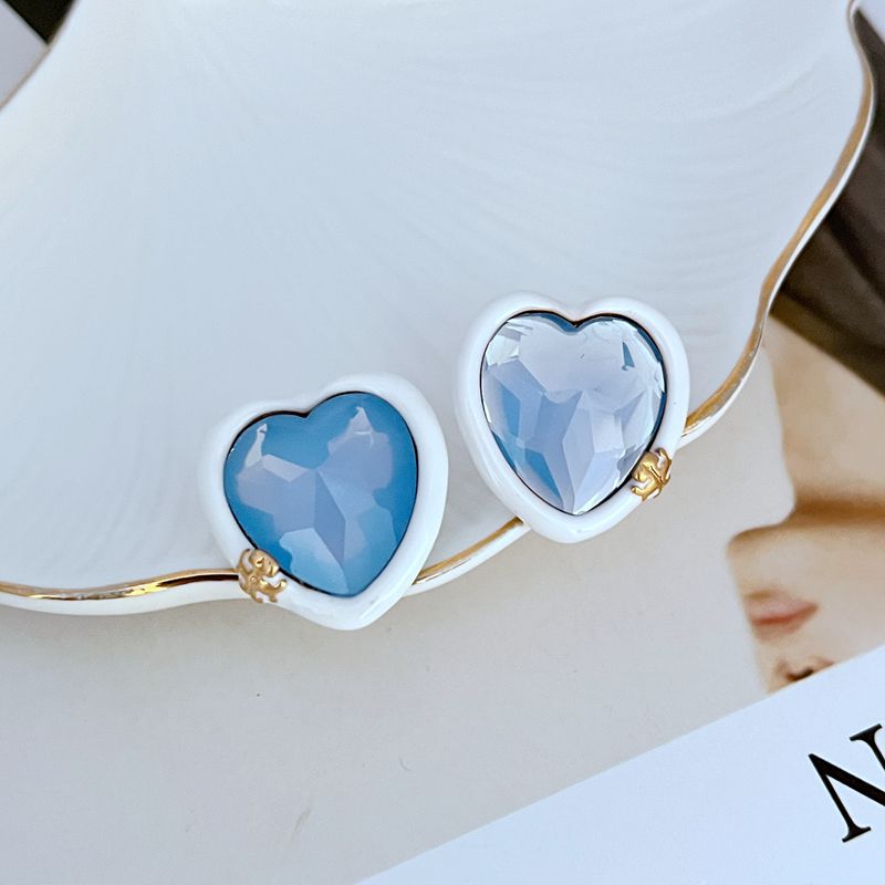Blue heart stud earrings with white acrylic bezel and gold-tone posts