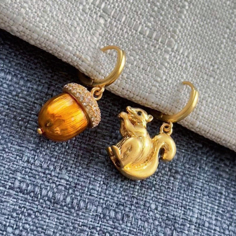Gold-tone squirrel and acorn charm hoop earrings with small crystal accents
