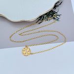 Gold openwork logo pendant necklace with round cutout emblem on thin chain