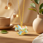 Enamel rocking horse necklace with gold chain and blue horse charm, flat rocking base