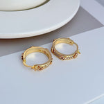 Gold hoop earrings with logo engraving and crystal pavé border