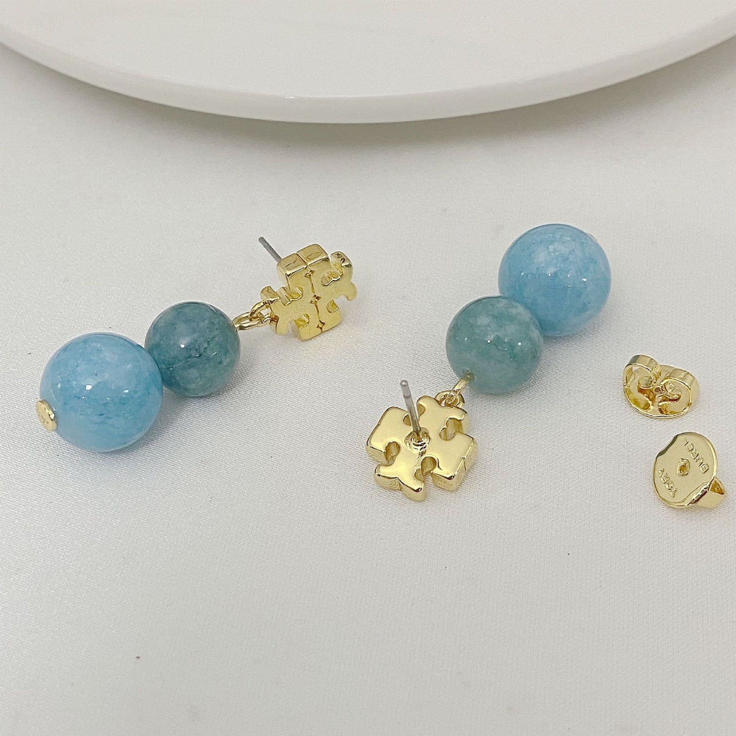 Logo-Perlen-Achat-Ohrstecker, blaue Kugeln und goldfarbenes Logo-Element