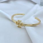 Gold openwork square logo metal bangle, close side view of centerpiece