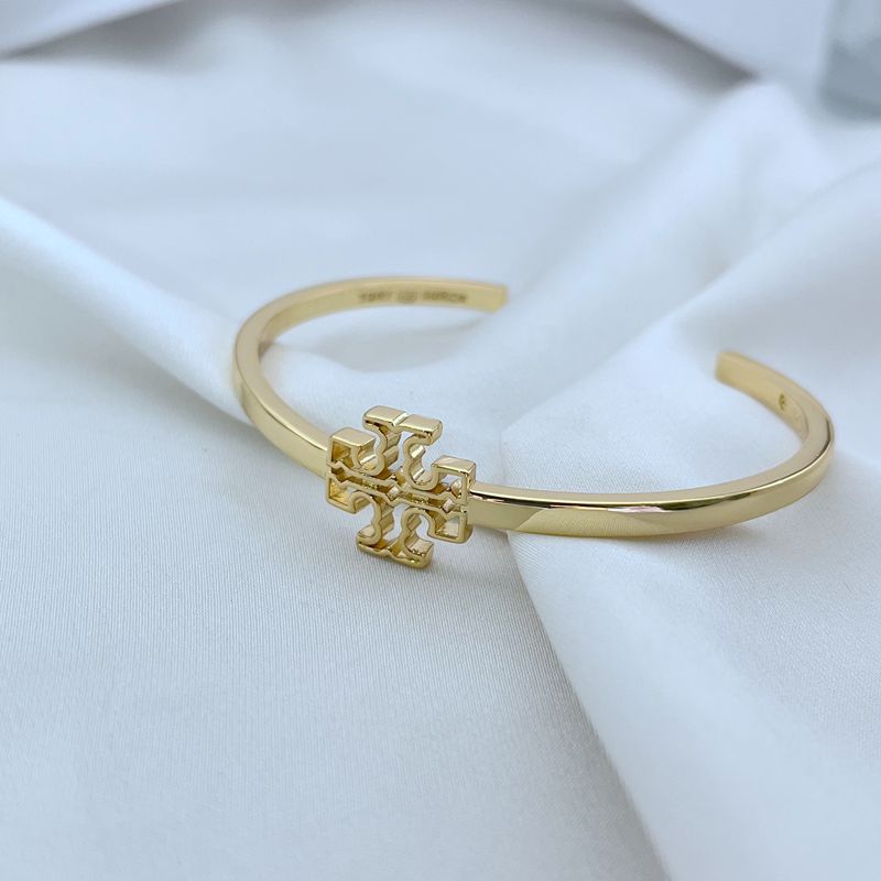 Gold openwork square logo metal bangle, close side view of centerpiece